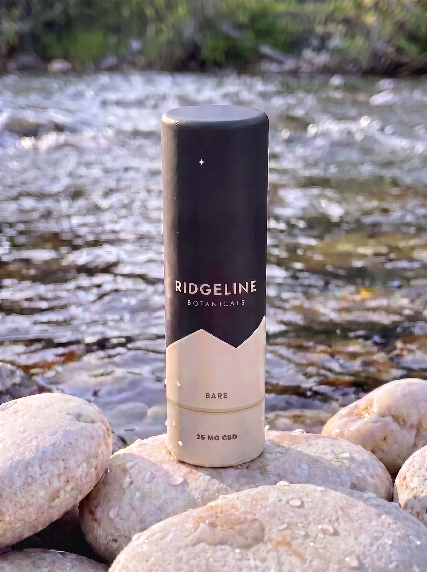 Bare tube standing on smooth creek stones beside moving water